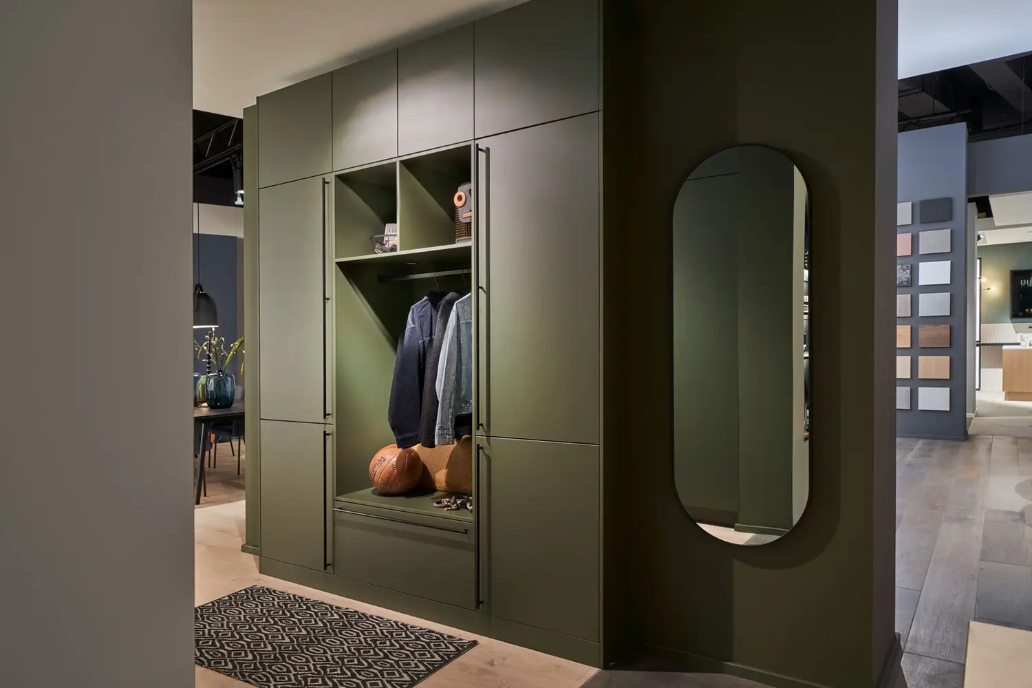 Vestiaire d’entrée vert kaki avec penderie intégrée, banc et nombreux rangements.