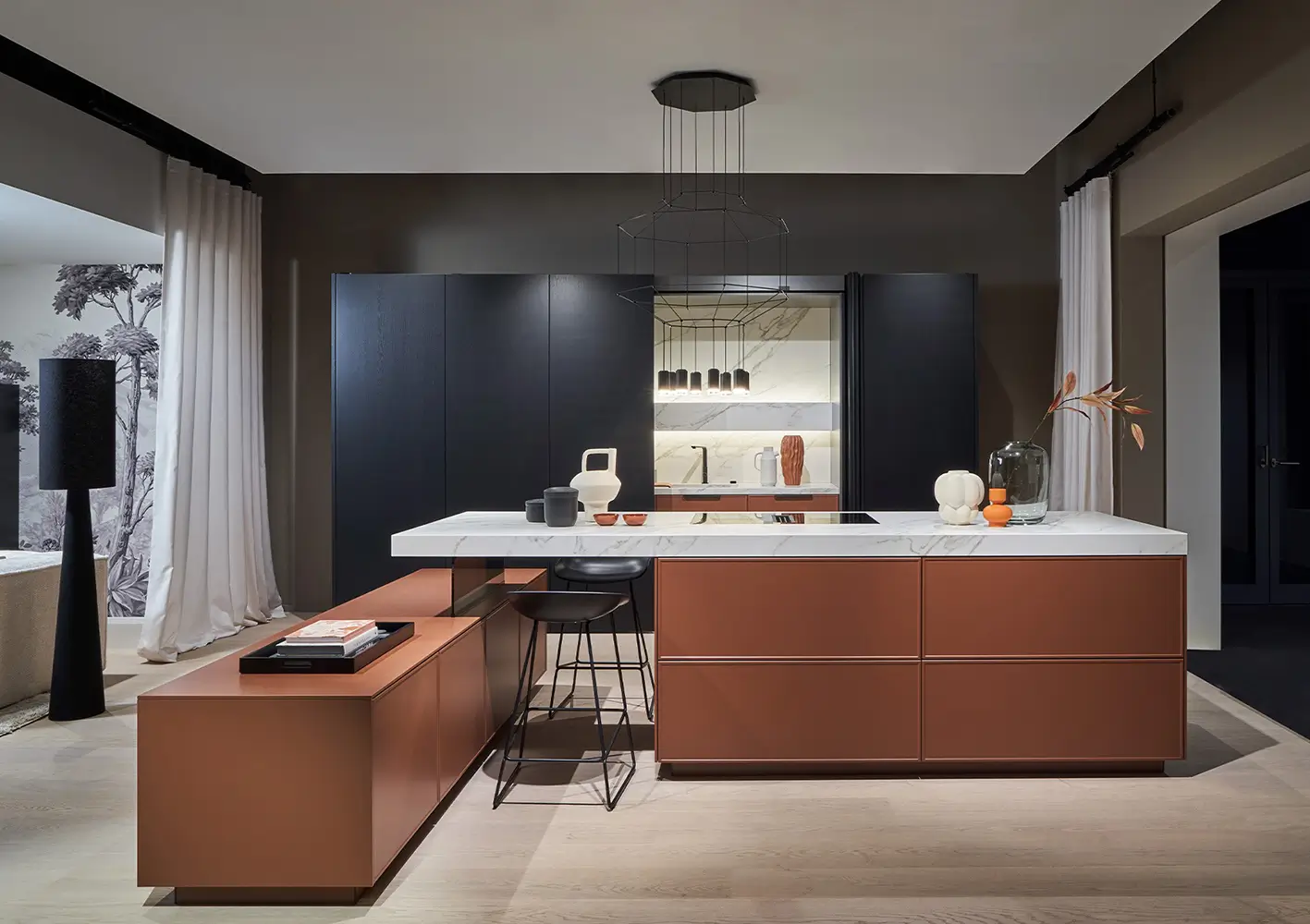 Cuisine design noir et ocre avec grand îlot central au plan de travail effet marbre.